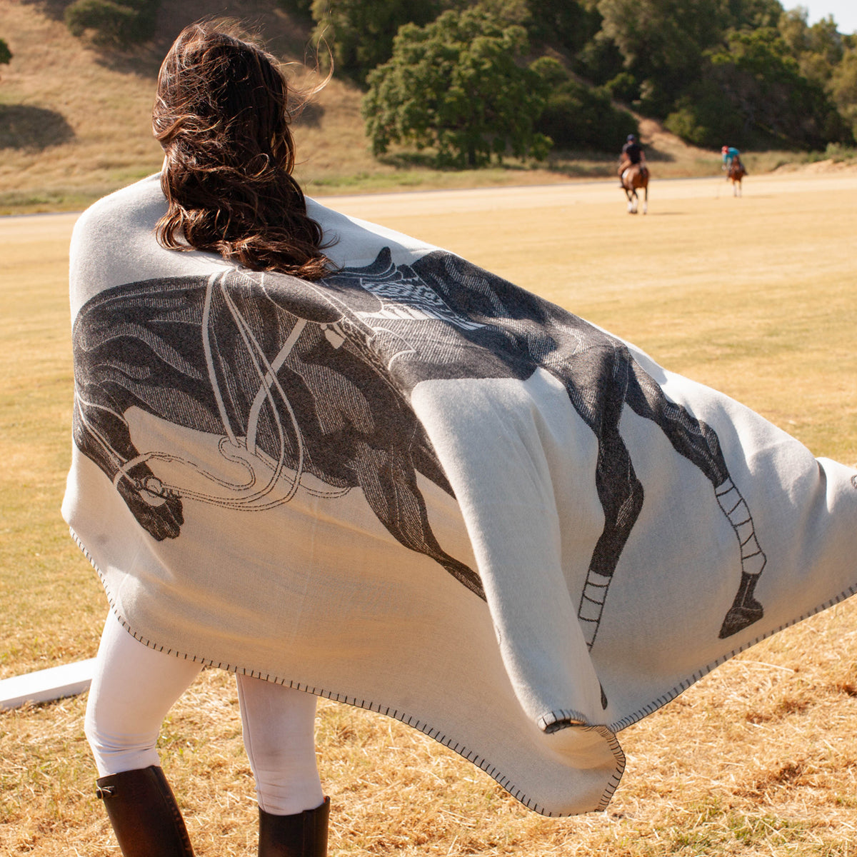 Pony Alpaca Throw draped over woman standing on polo field