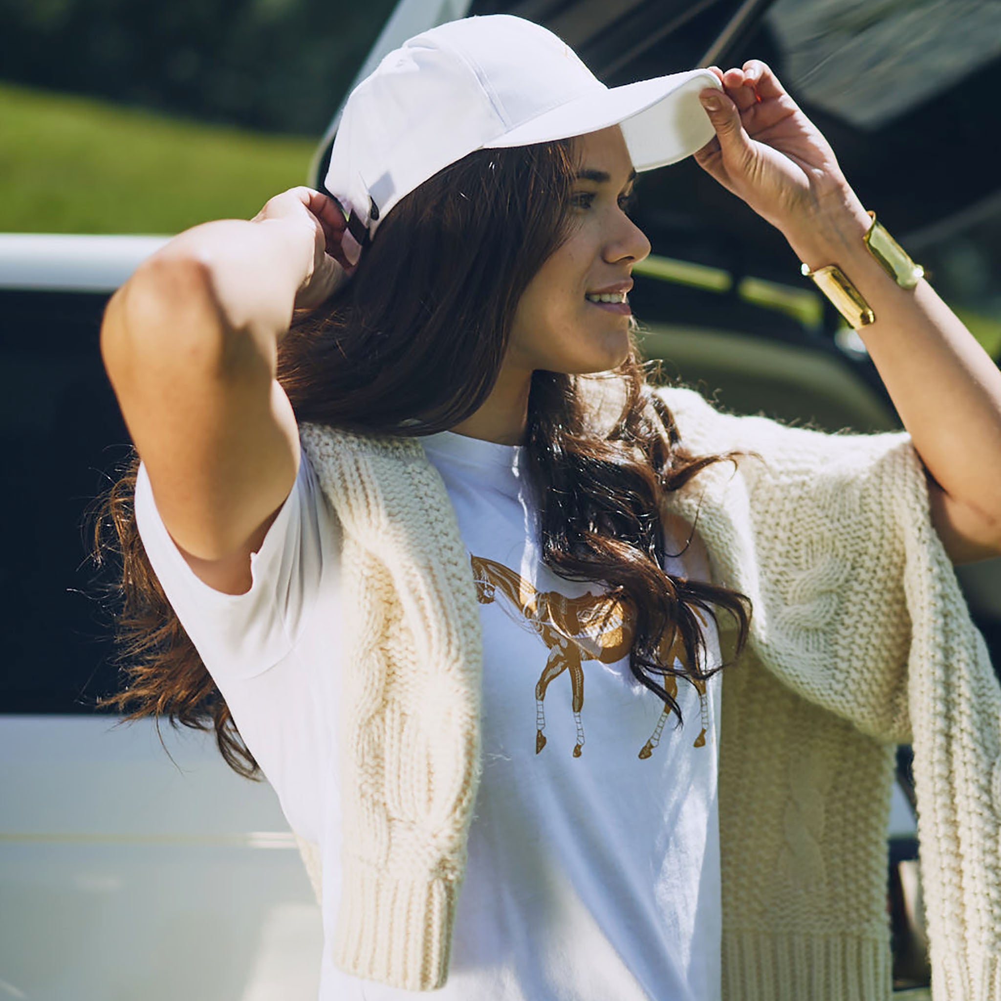 woman-wearing-stick-and-ball-accessories-unisex-embroidered-baseball-cap-white-gold-with-polo-pony-t-shirt-and-sarah-cable-knit-sweater
