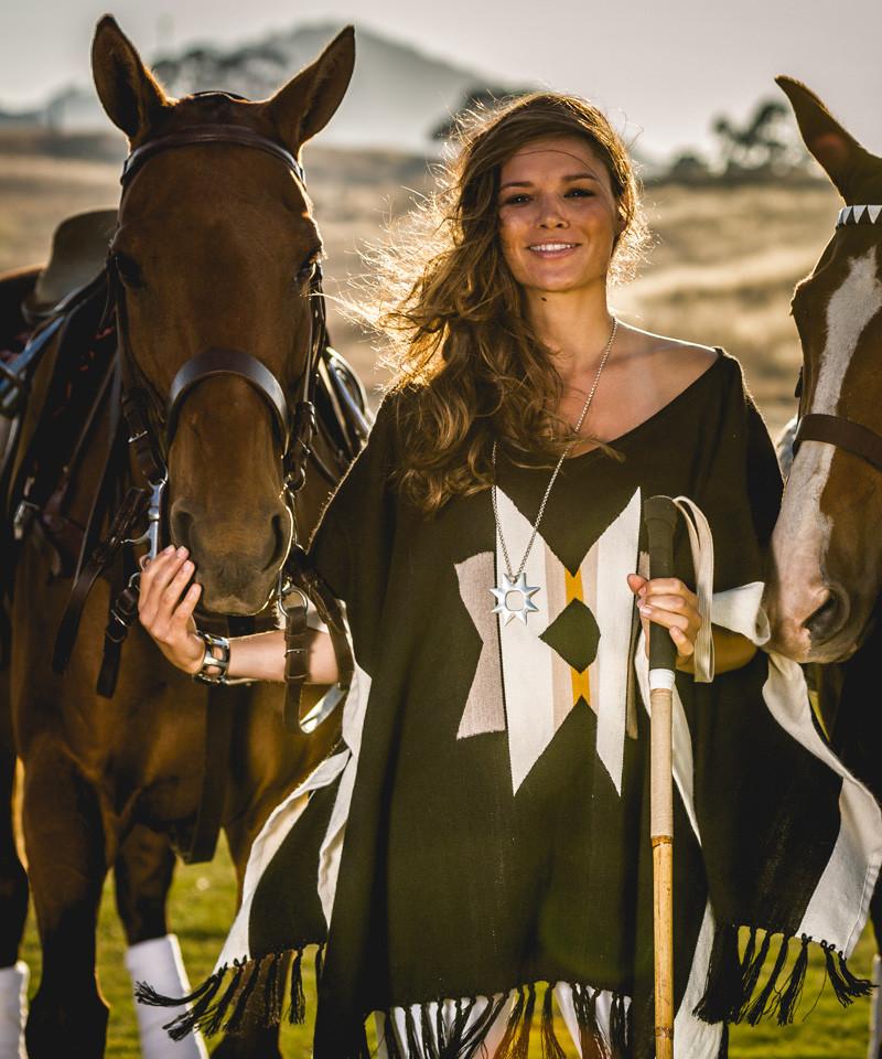 woman-on-a-polo-field-with-horses-wearing-the-stick-and-ball-apparel-unisex-inca-star-alpaca-poncho-black