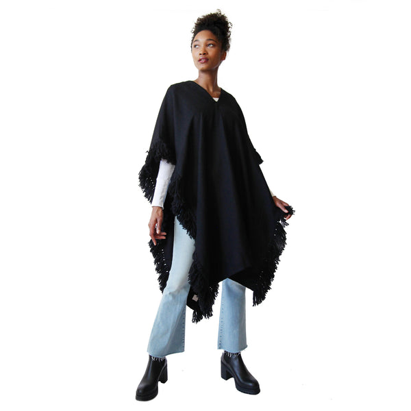 Woman wearing Handwoven Long Fringed Alpaca Poncho in Black - Stick & Ball 