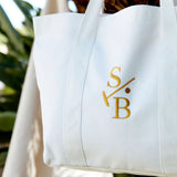 Cotton Canvas White Embroidered Tote with Stick & Ball Logo in Gold, hanging 
