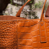 Stick & Ball luxury Faux Coco Italian Weekender placed in a desert landscape showing off the hand debossed details of the Nile Croc pattern